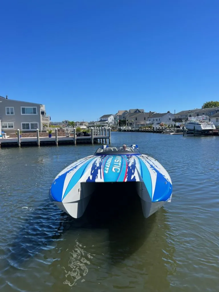 Slide: The Image of 2022 Mystic Powerboats C4000 catamaran docked in a scenic marina. - 9