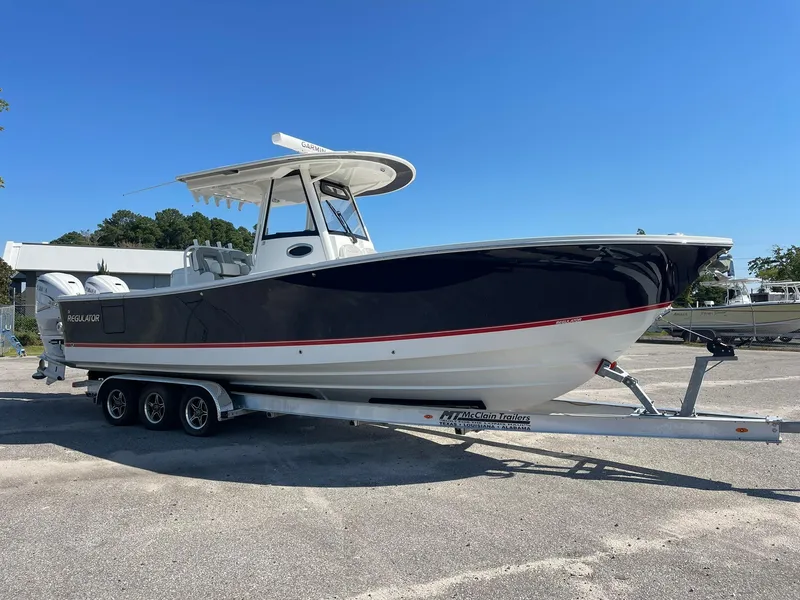 Slide: The Image of 2022 Regulator 31 boat on trailer under clear blue sky. - 0