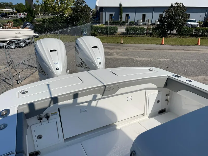Slide: The Image of 2022 Regulator 31 boat with dual outboard engines, docked in a marina. - 12