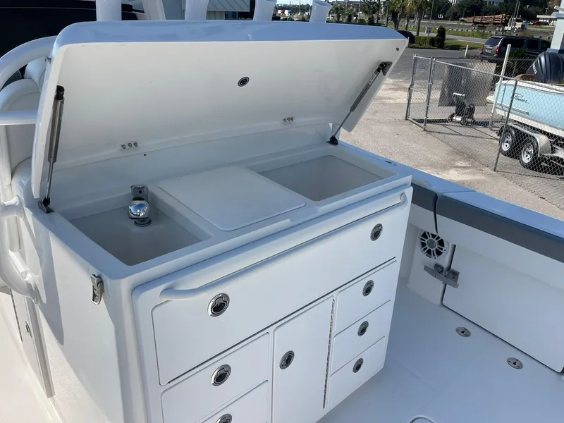 Slide: The Image of 2022 Regulator 31 boat with open storage compartments and sink. - 6