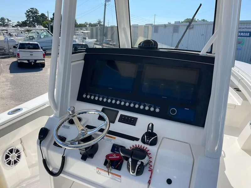 Slide: The Image of 2022 Regulator 31 boat dashboard with dual screens and steering wheel. - 7
