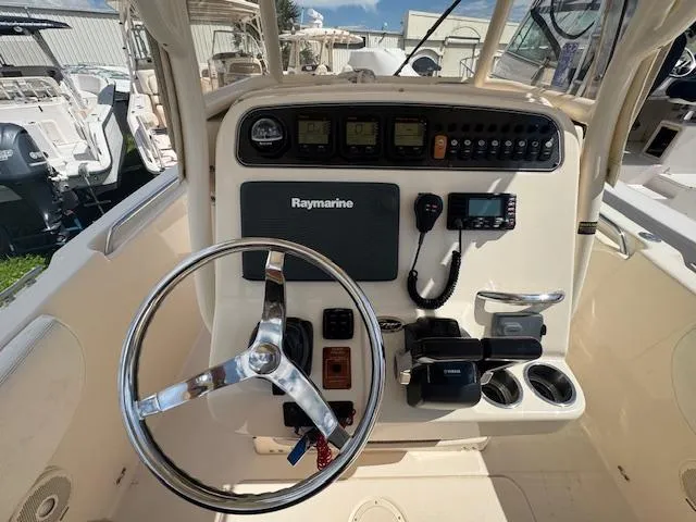 Slide: The Image of 2015 Grady-White Fisherman 257 boat dashboard with steering wheel and navigation controls. - 24