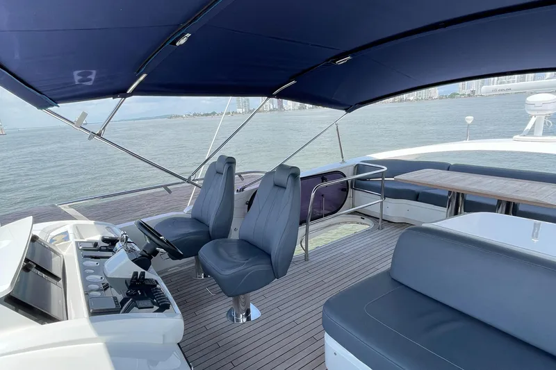 Slide: The Image of 2017 Princess S65 yacht deck with seating and helm, overlooking calm waters. - 3