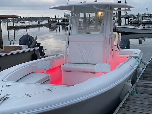 Slide: The Image of 2024 Contender 28 Tournament boat with red interior lights docked at a marina. - 13