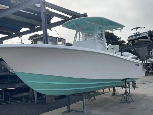 Slide: The Image of 2024 Contender 28 Tournament boat with teal accents on display at a marina. - 15