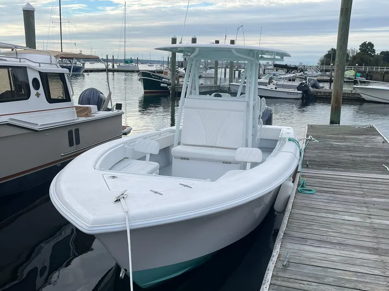 Slide: The Image of 2024 Contender 28 Tournament boat docked at marina, featuring sleek white design. - 2