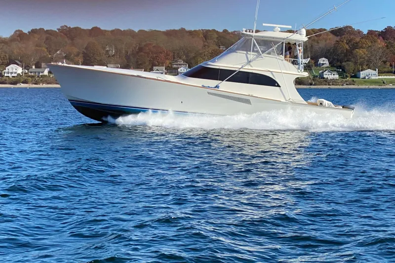 Slide: The Image of 1999 Hines-Farley SPORTFISHERMAN yacht cruising on a scenic coastal waterway. - 0