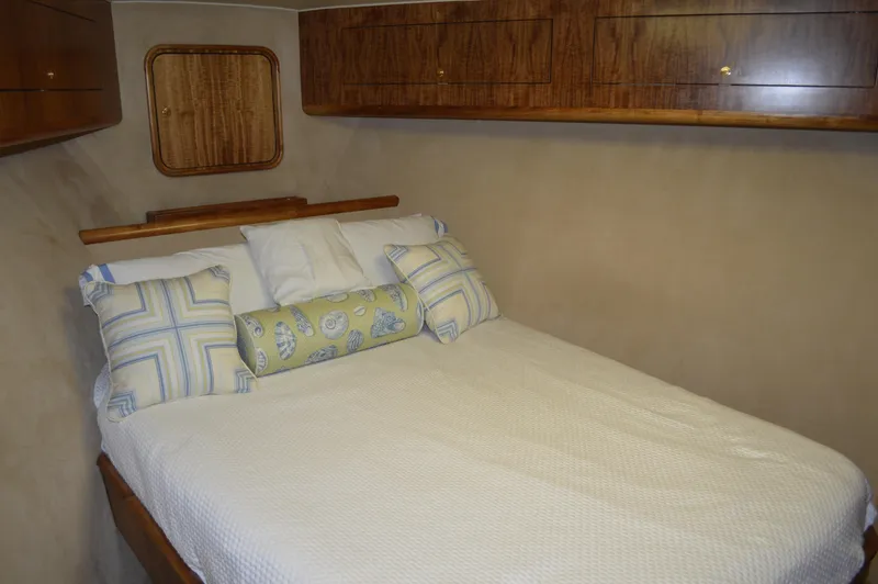 Slide: The Image of Cozy bedroom in 1999 Hines-Farley SPORTFISHERMAN yacht with wooden cabinets and decorative pillows. - 16