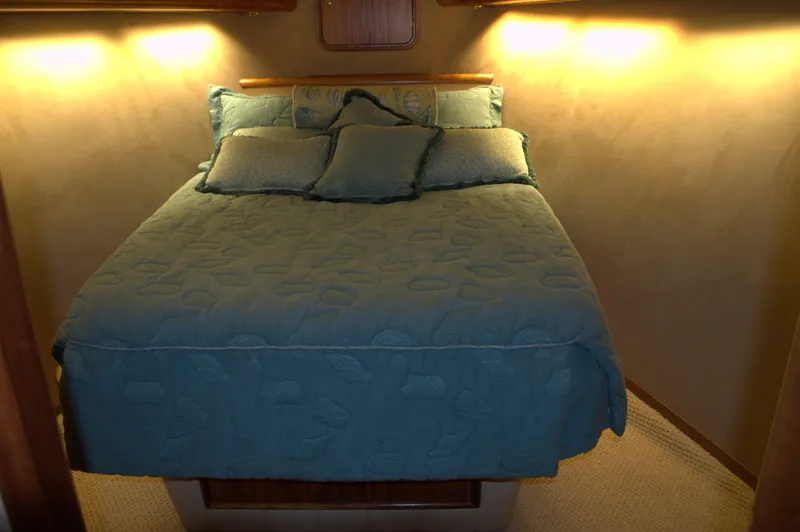 Slide: The Image of 1999 Hines-Farley SPORTFISHERMAN cabin with cozy bed and soft lighting. - 17