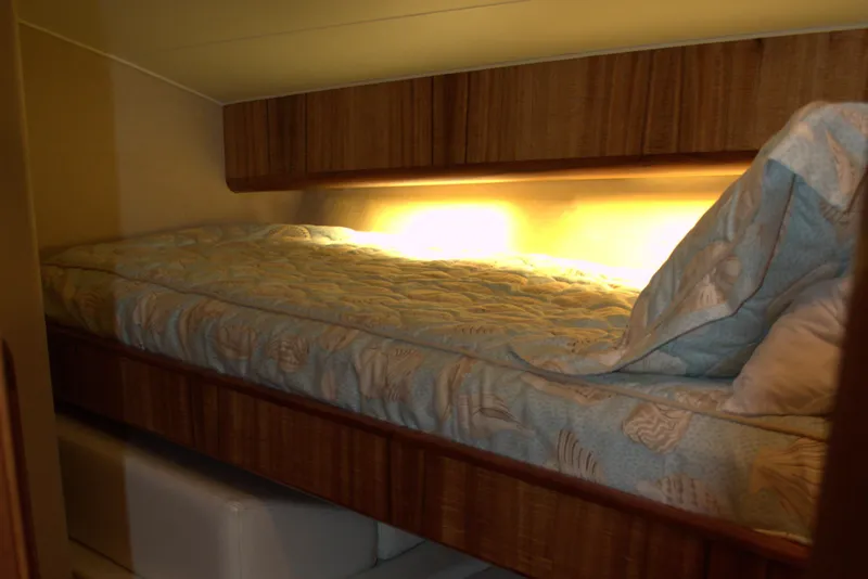 Slide: The Image of 1999 Hines-Farley SPORTFISHERMAN cabin with cozy bed and warm lighting. - 18