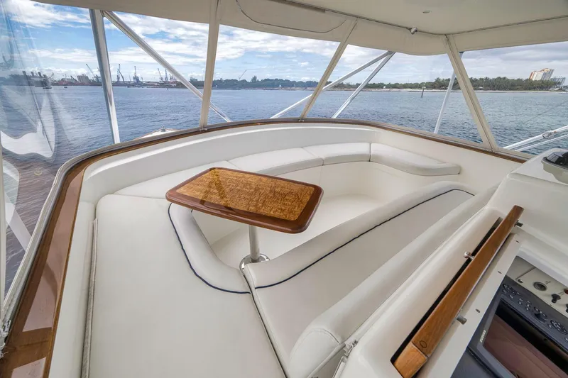 Slide: The Image of 1999 Hines-Farley SPORTFISHERMAN yacht interior with white seating and wooden table, overlooking water. - 47