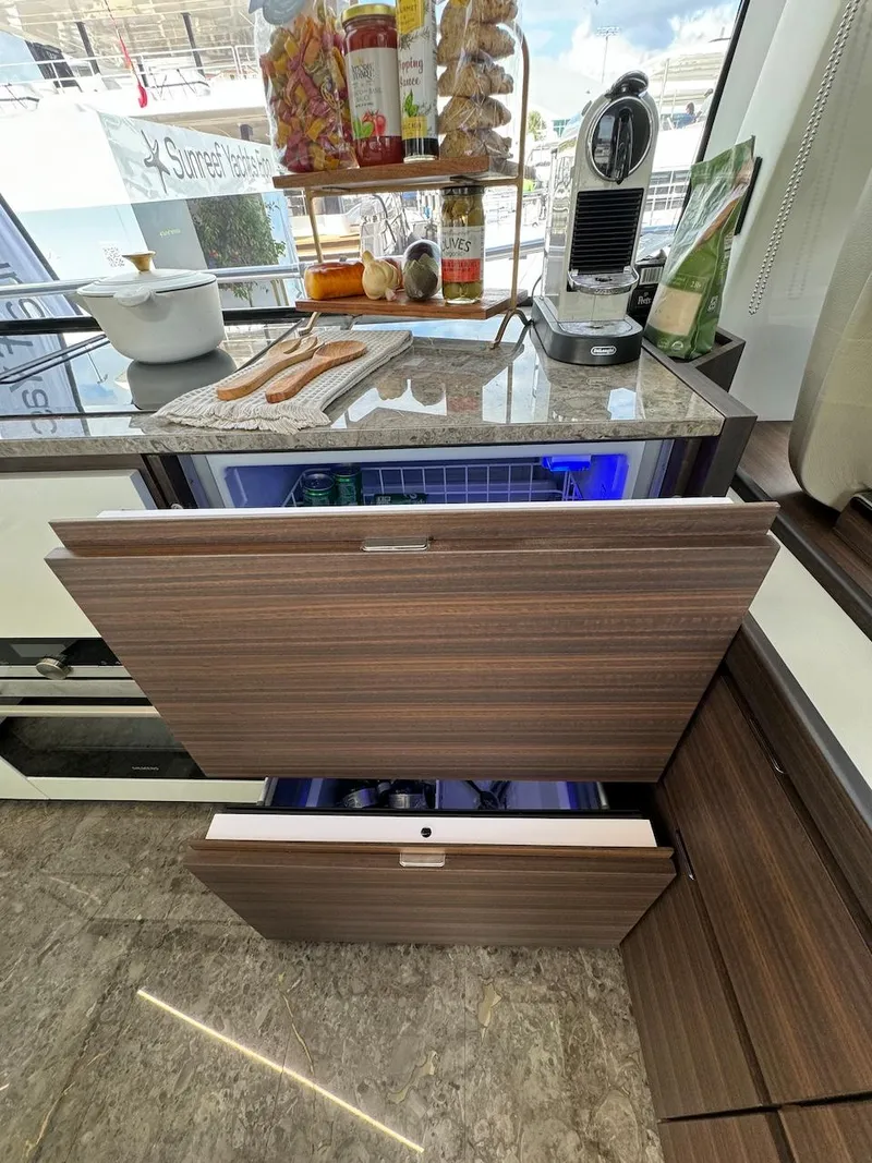 Slide: The Image of Luxury yacht kitchen with modern appliances, featuring wood cabinetry and marble countertops on Aicon 66 Vivere 2024. - 22