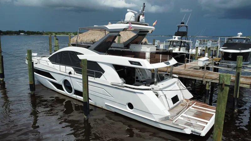 Slide: The Image of Luxury 2024 Aicon 66 Vivere yacht docked at marina under cloudy sky. - 3