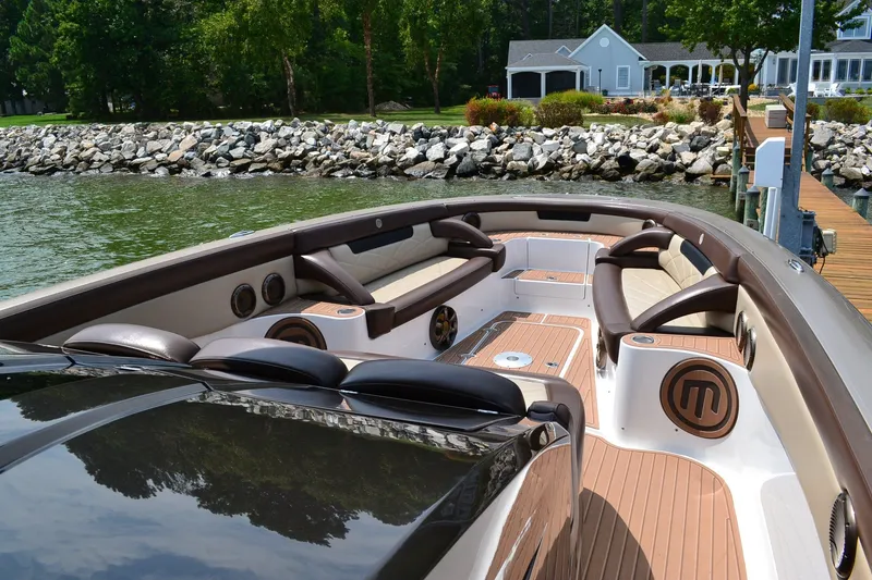 Slide: The Image of 2016 Mystic Powerboats M4200 with luxurious seating and sleek design by the water. - 12