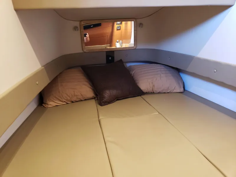 Slide: The Image of Cozy cabin interior of 2016 Mystic Powerboats M4200 with pillows and small window. - 5