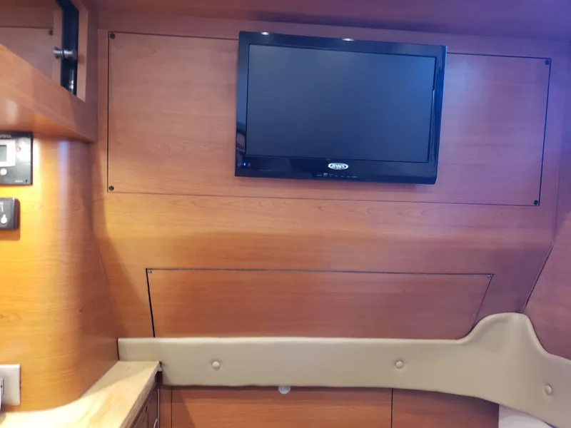 Slide: The Image of Interior of 2016 Mystic Powerboats M4200 with wall-mounted TV and wooden paneling. - 8