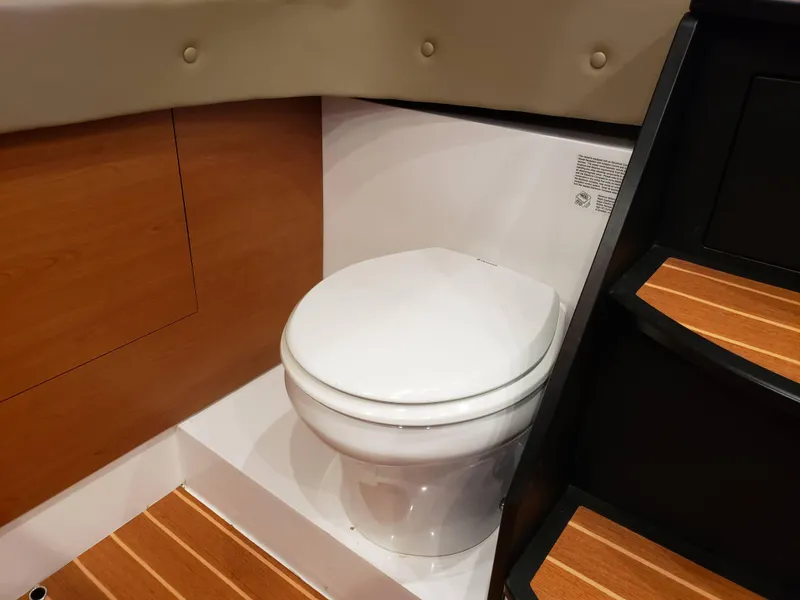 Slide: The Image of 2016 Mystic Powerboats M4200 interior bathroom with modern toilet and wooden accents. - 9