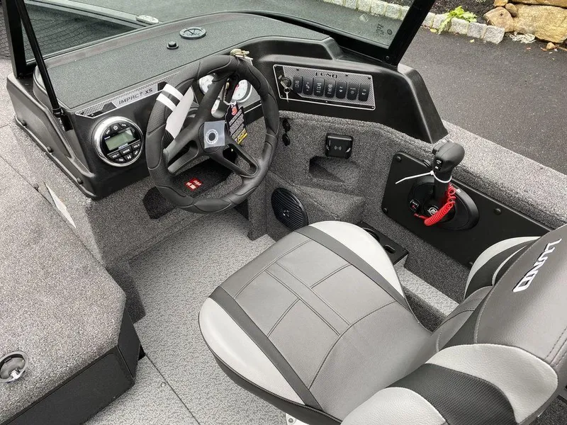 Slide: The Image of 2025 Lund 1775 Impact XS Sport boat interior with steering wheel and control panel. - 10