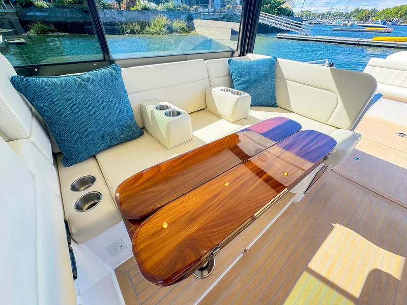 Slide: The Image of Luxurious seating area on 2024 MJM 4 boat with elegant wood table and blue cushions. - 17