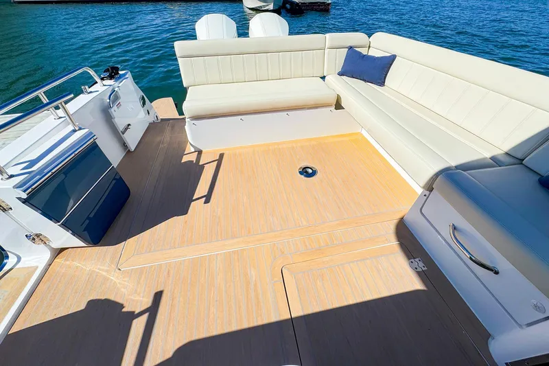 Slide: The Image of 2024 MJM 4 boat deck with beige seating and blue cushion on water. - 20