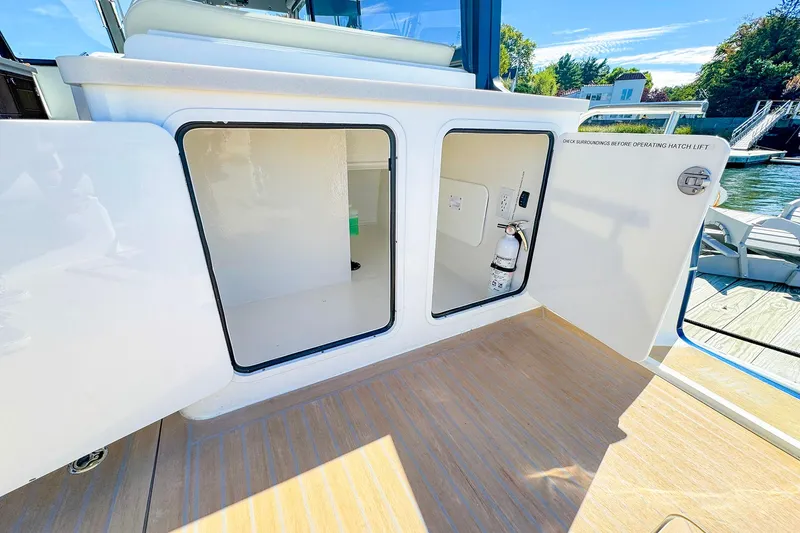 Slide: The Image of 2024 MJM 4 boat storage compartments with open doors, showcasing interior space and equipment. - 23