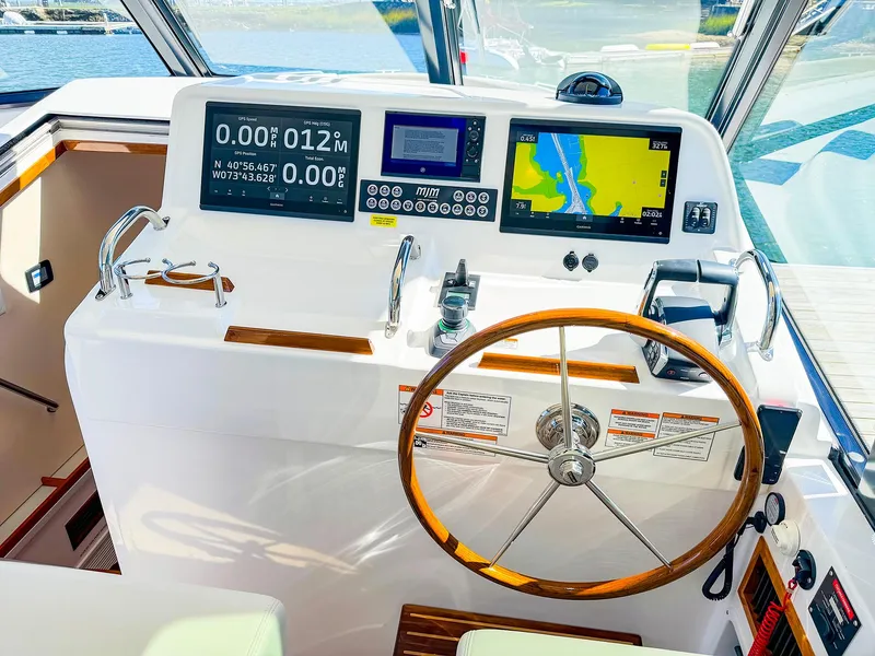 Slide: The Image of 2024 MJM 4 boat helm with navigation screens and wooden steering wheel. - 4