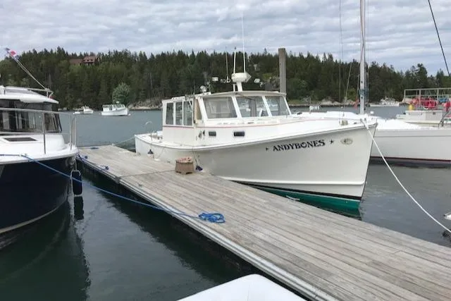 Slide: The Image of 1972 REPCO Buxton Downeast Hardtop Cruiser docked at a marina with scenic background. - 32