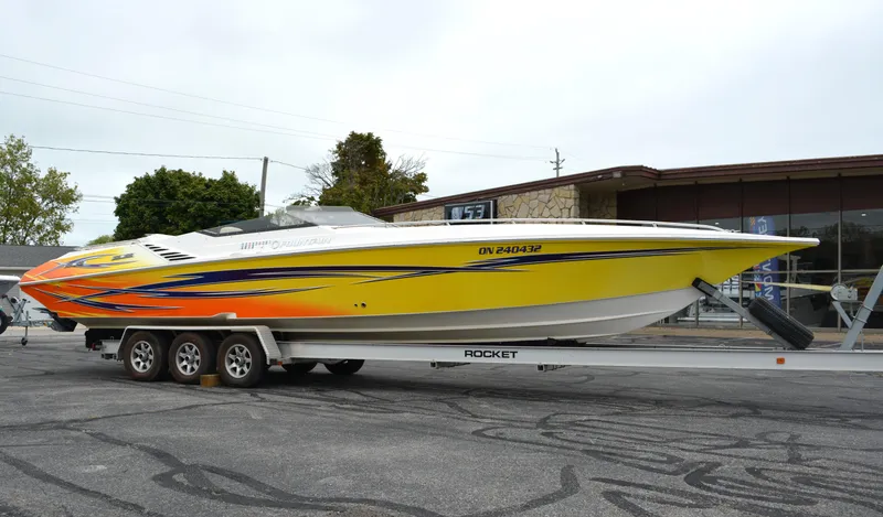 The Image of 2007 Fountain 35 Executioner speedboat on trailer, vibrant yellow and orange design. - 0