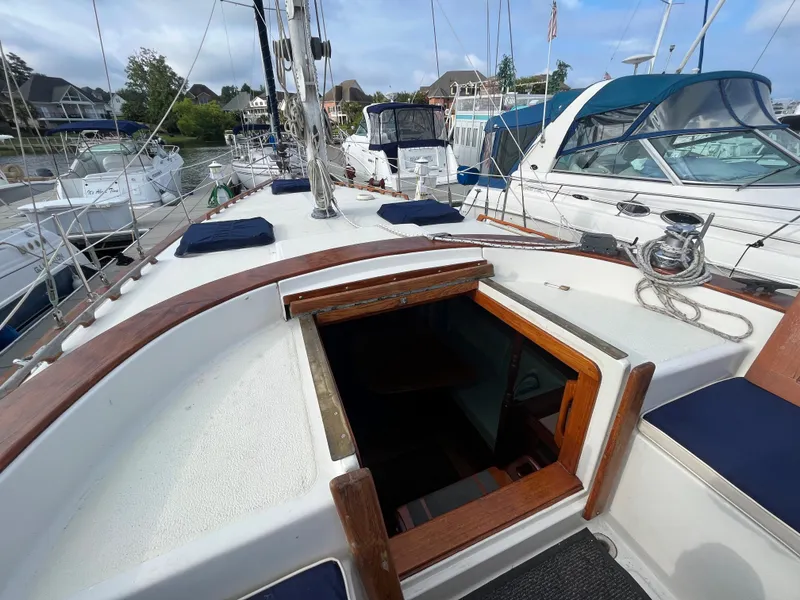 Slide: The Image of 1981 Endeavour 40 sailboat deck with open cabin hatch, docked in marina. - 14