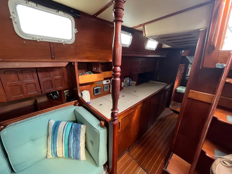 Slide: The Image of Interior of 1981 Endeavour 40 sailboat with wooden cabinetry and blue cushioned seating. - 16