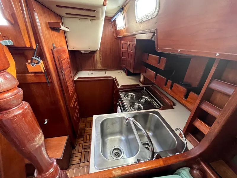 Slide: The Image of Interior of 1981 Endeavour 40 sailboat with wooden cabinetry and compact kitchen area. - 17
