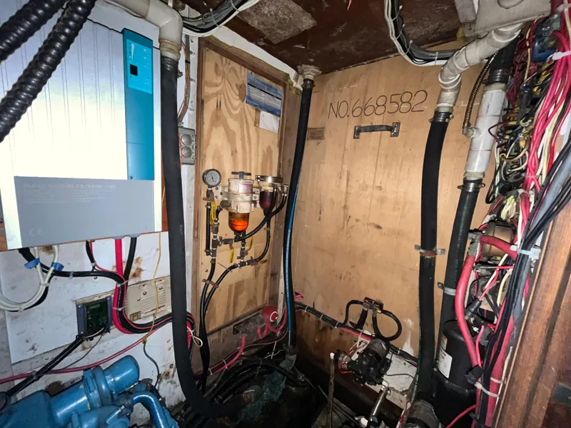 Slide: The Image of Engine room of a 1981 Endeavour 40 sailboat with wiring and equipment. - 23