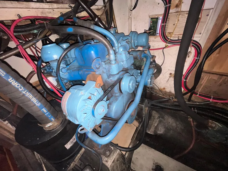 Slide: The Image of Engine compartment of a 1981 Endeavour 40 sailboat, featuring a blue marine engine. - 24