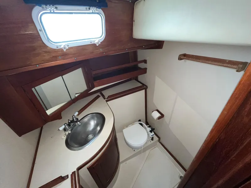 Slide: The Image of 1981 Endeavour 40 yacht bathroom with sink, toilet, and wooden accents. - 29