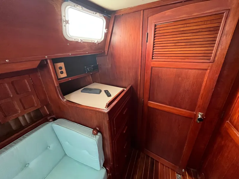 Slide: The Image of Interior of 1981 Endeavour 40 sailboat with wooden cabinetry and light blue seating. - 30