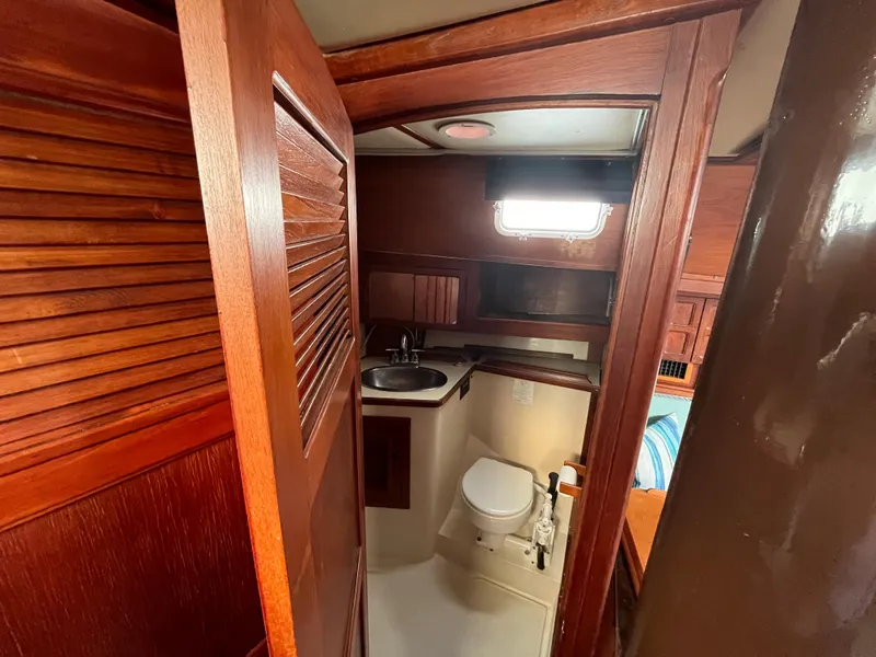 Slide: The Image of Interior of 1981 Endeavour 40 sailboat bathroom with wooden cabinetry and compact design. - 31