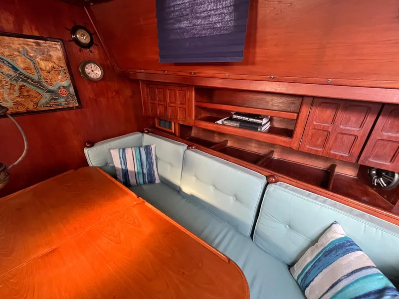 Slide: The Image of Cozy interior of 1981 Endeavour 40 sailboat with wooden table and cushioned seating. - 37