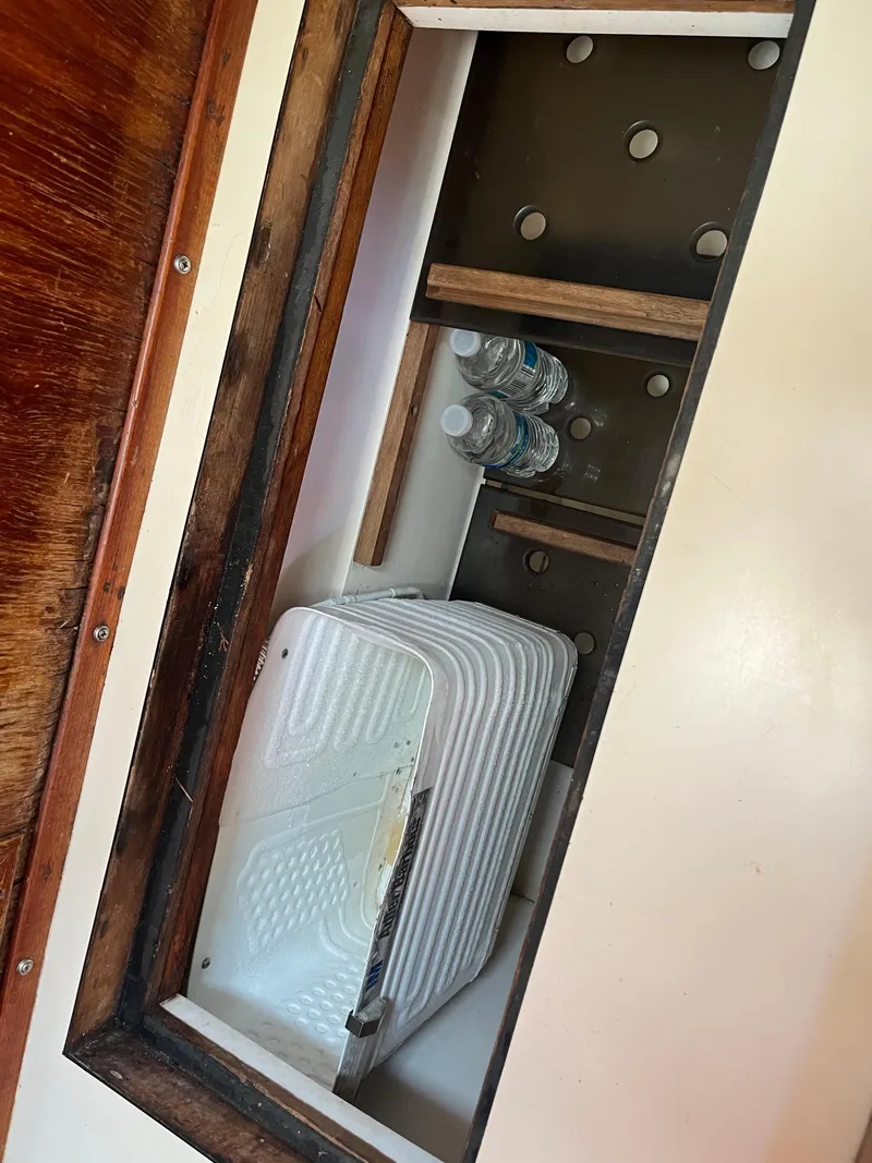 Slide: The Image of Storage compartment in 1981 Endeavour 40 sailboat with shelves and water bottles. - 40