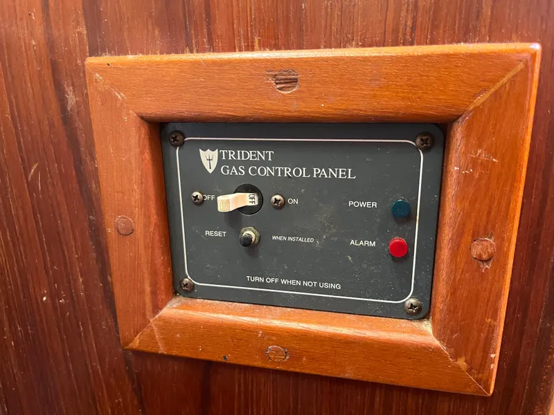 Slide: The Image of Trident gas control panel on 1981 Endeavour 40 boat, wooden frame, power and alarm indicators. - 43