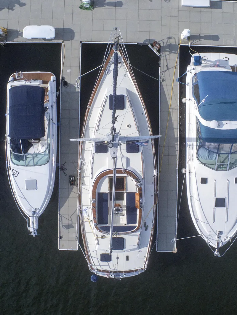 Slide: The Image of Aerial view of a 1981 Endeavour 40 sailboat docked between two motorboats. - 47