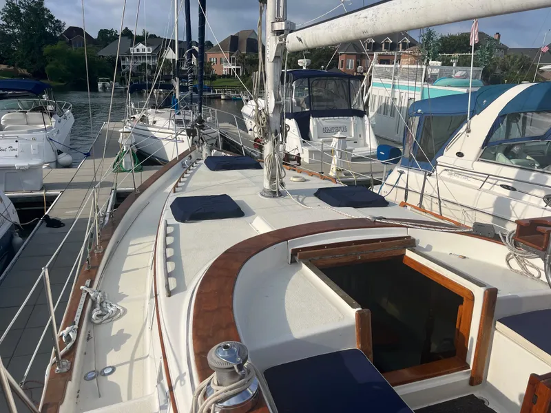 Slide: The Image of 1981 Endeavour 40 sailboat docked at marina, showcasing deck and cabin entrance. - 5