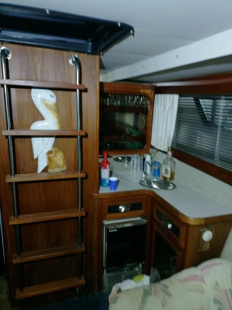 Slide: The Image of 1988 Carver Mariner 32 yacht interior with kitchenette and pelican decor. - 12