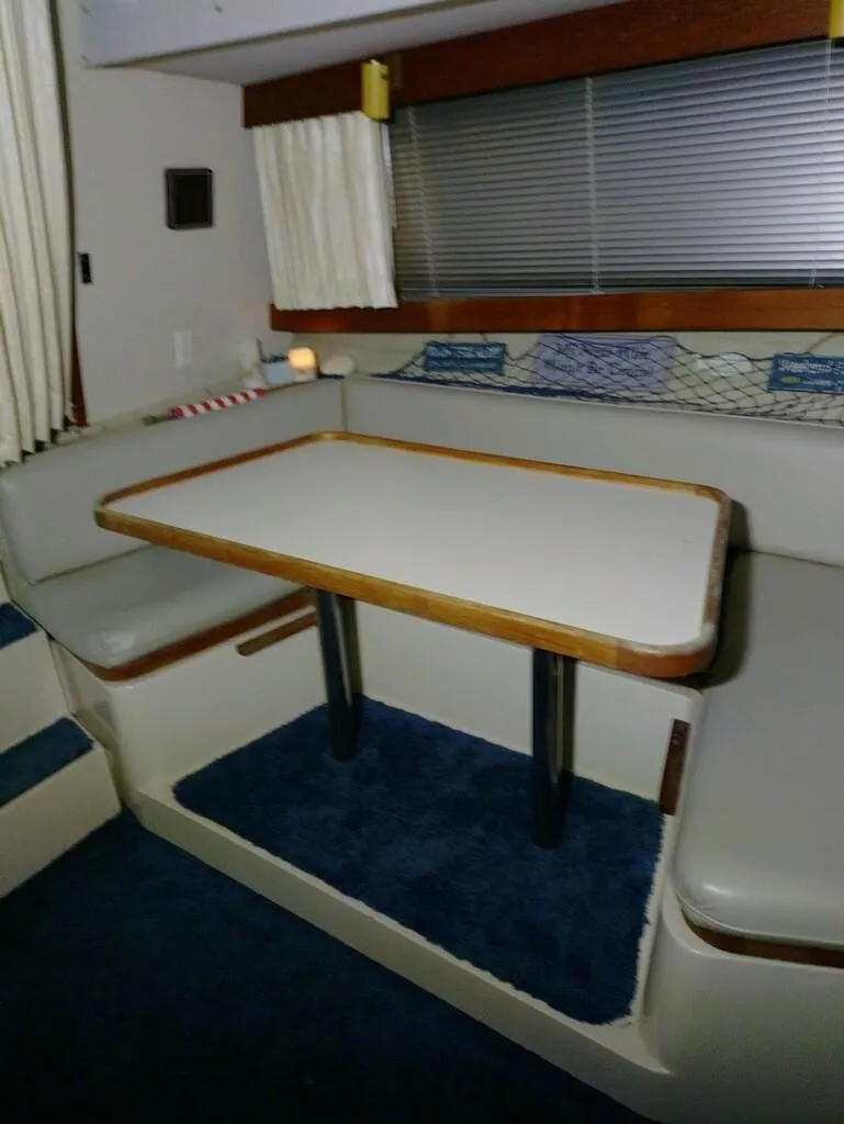 Slide: The Image of Interior of 1988 Carver Mariner 32 yacht with dining area and cushioned seating. - 23