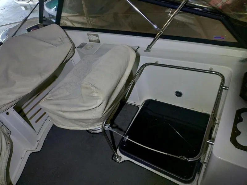 Slide: The Image of 1988 Carver Mariner 32 interior with covered seats and storage compartment. - 7