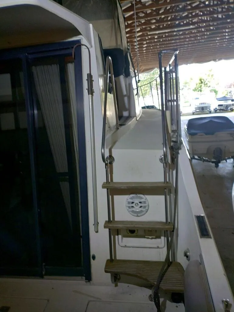 Slide: The Image of 1988 Carver Mariner 32 yacht with wooden steps and covered dock. - 14