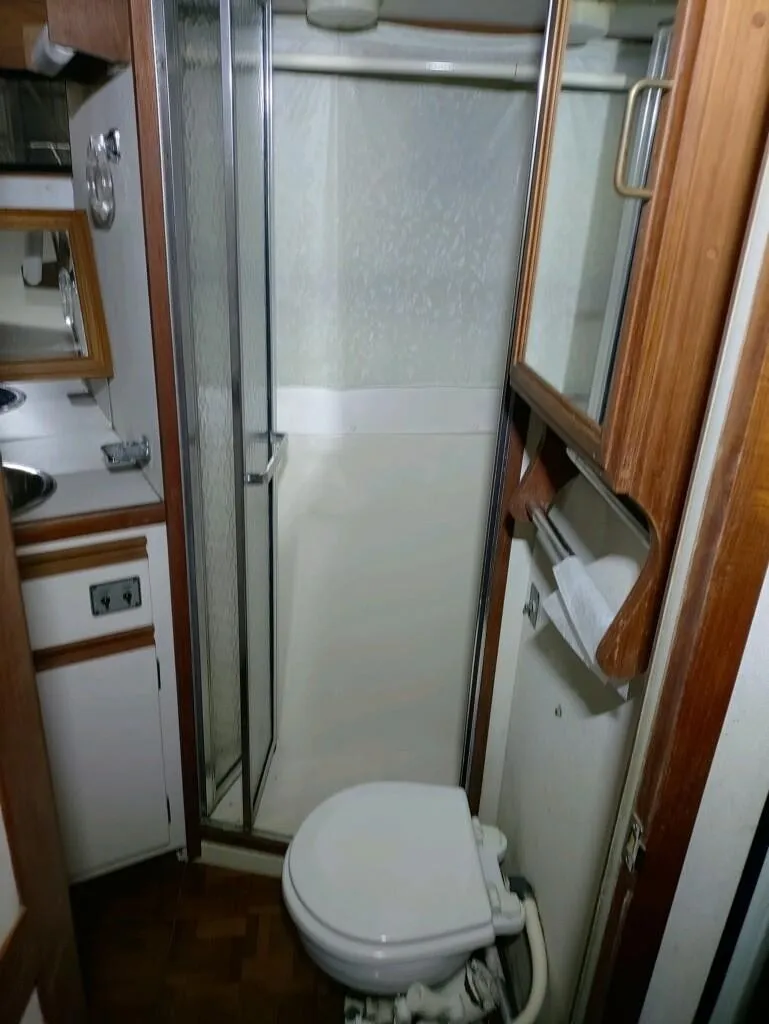 Slide: The Image of 1988 Carver Mariner 32 bathroom with shower, toilet, and wooden cabinetry. - 17