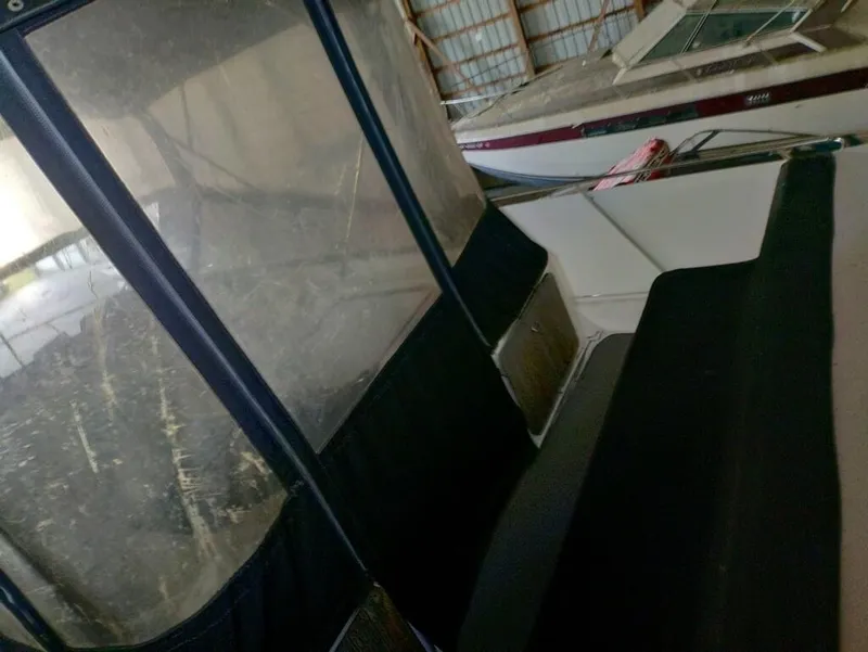 Slide: The Image of 1988 Carver Mariner 32 interior with seating and windows in a storage facility. - 6
