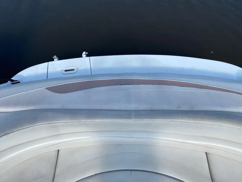 Slide: The Image of 2002 Four Winns 225 Sundowner boat interior with curved seating and water view. - 2