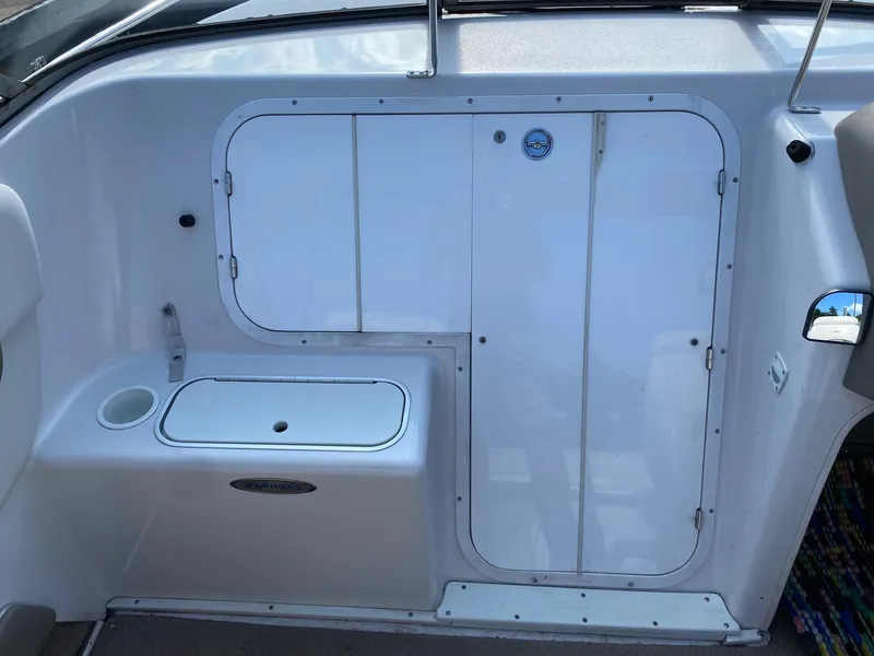 Slide: The Image of 2002 Four Winns 225 Sundowner boat interior with storage compartments and seating area. - 3