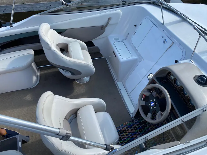 Slide: The Image of 2002 Four Winns 225 Sundowner boat interior with white seating and steering console. - 4